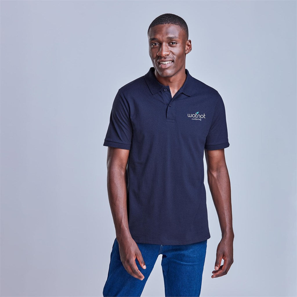 Man wearing a navy blue polo shirt with a logo on a light gray background

