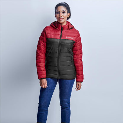 Woman wearing a red and black puffer jacket on a light gray background


