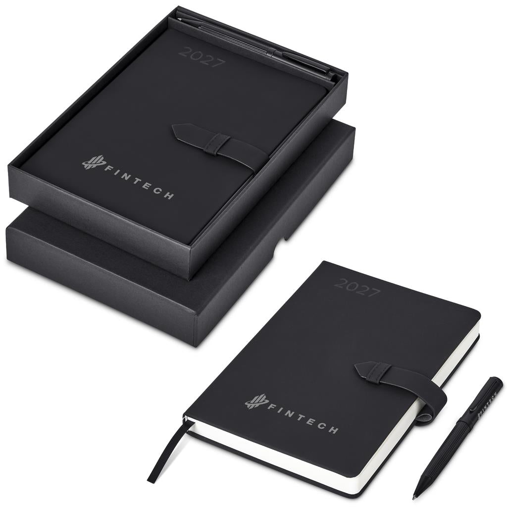 A black 2027 Fintech planner with a black leather strap closure, shown both inside its presentation box and open on a white background, accompanied by a black pen.

