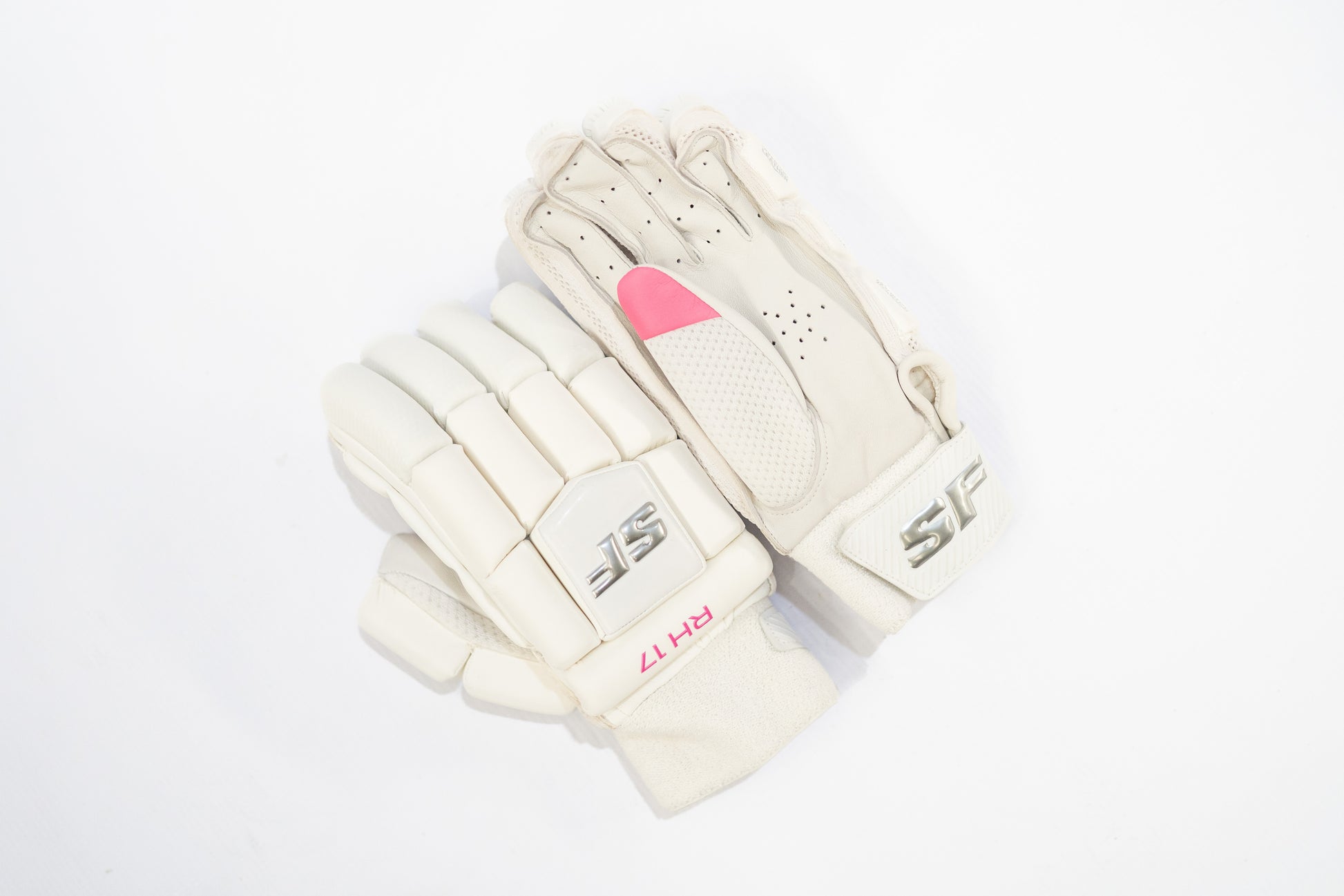 Pair of white batting gloves with pink accents on a white background

