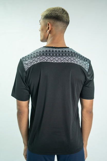 Man wearing a black t-shirt with patterned shoulders on a white background


