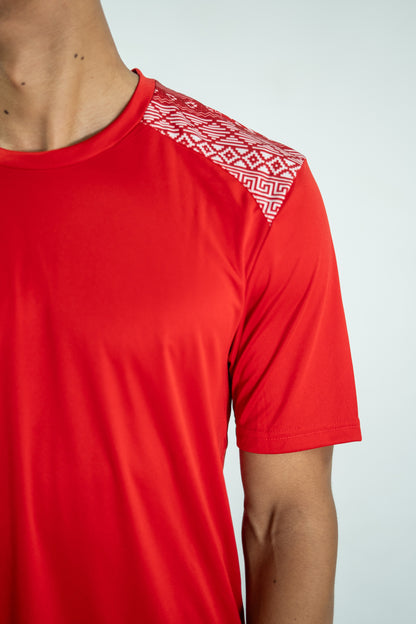 Red athletic shirt with geometric pattern on shoulder against a white background

