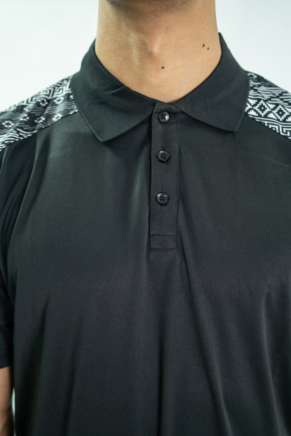 Black polo shirt with patterned shoulders on a plain background

