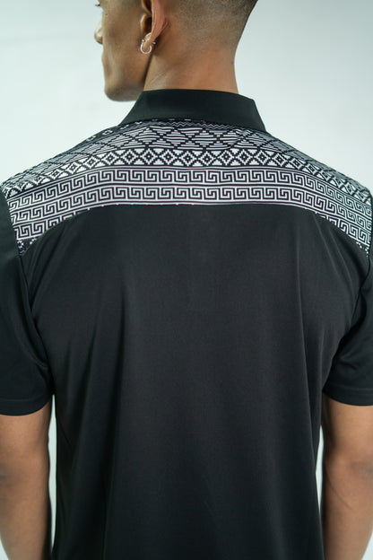 Black shirt with geometric pattern on collar worn by a person against a white background

