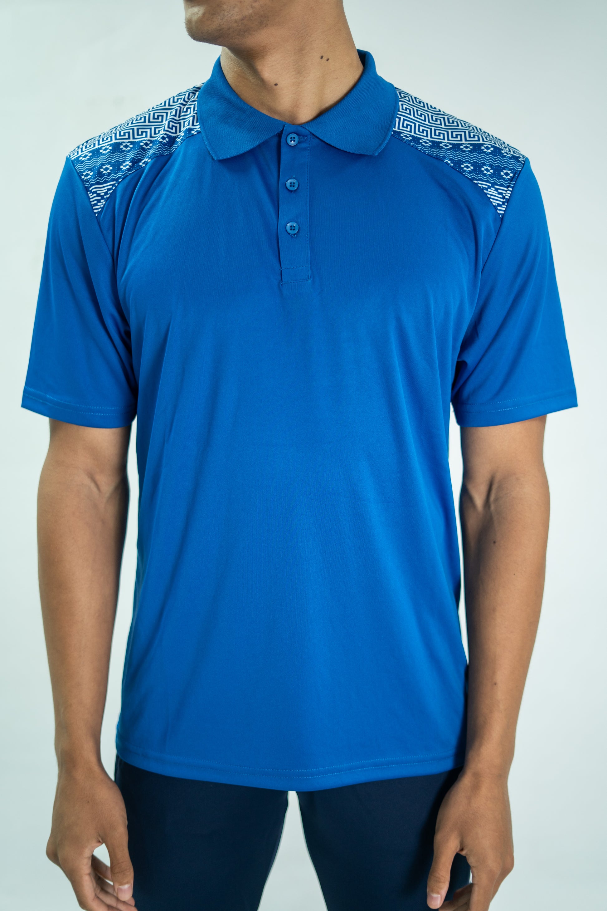 Blue polo shirt with patterned shoulders on a white background

