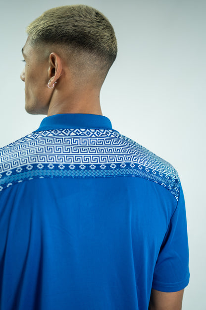 Blue polo shirt with white geometric pattern on a plain background

