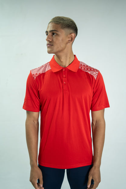 Man wearing a red polo shirt with white embroidery on a plain background


