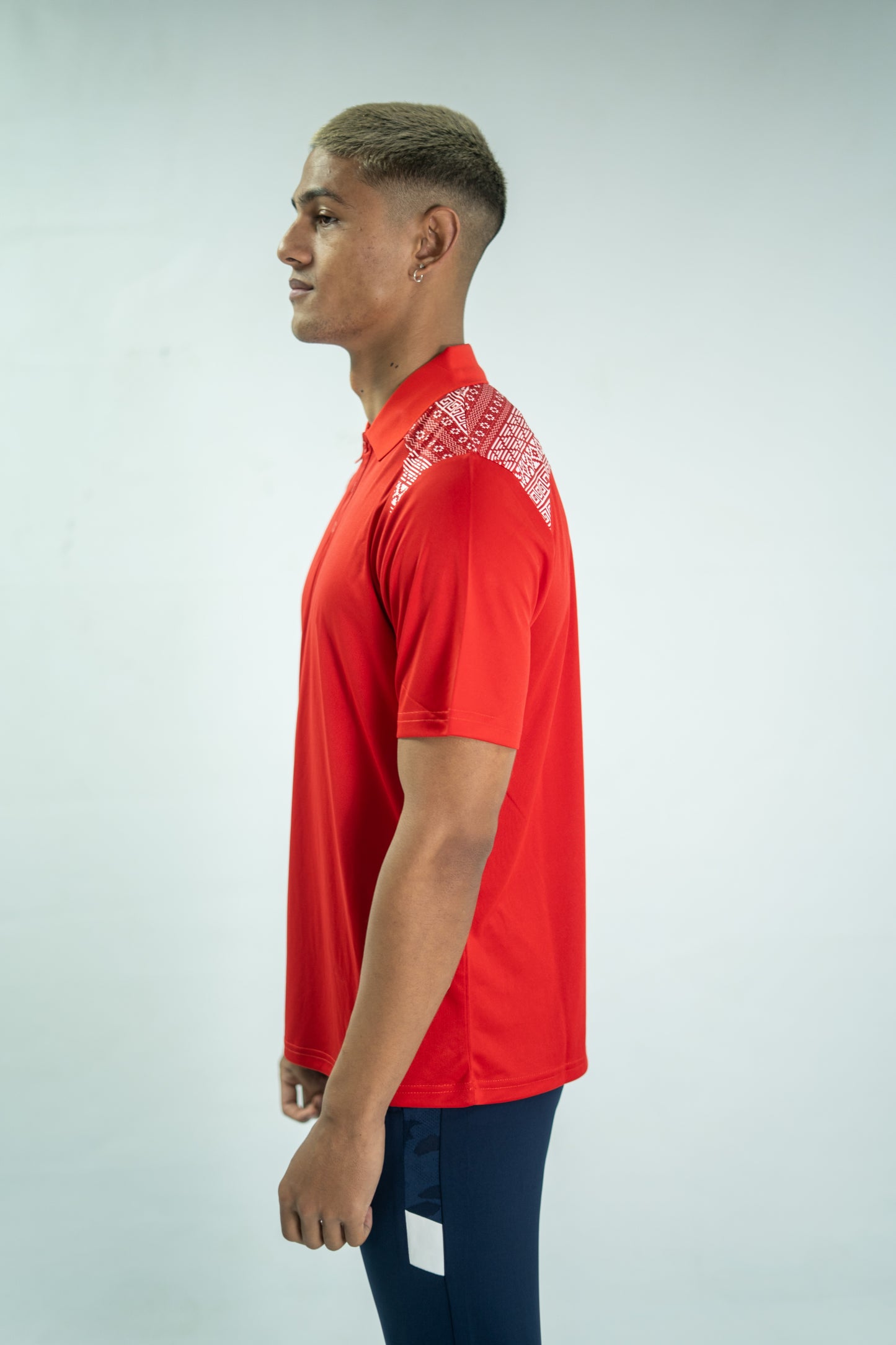 Person wearing a red polo shirt with a white pattern on a light gray background

