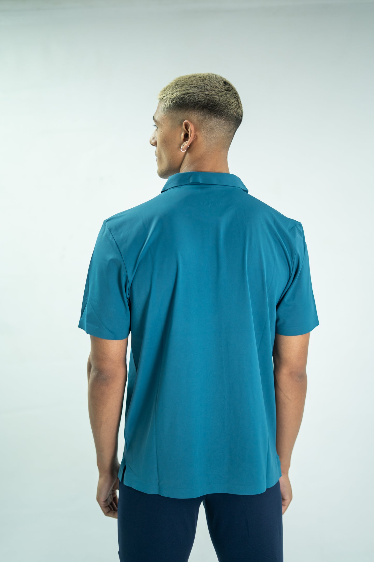 Man wearing a blue polo shirt against a white background

