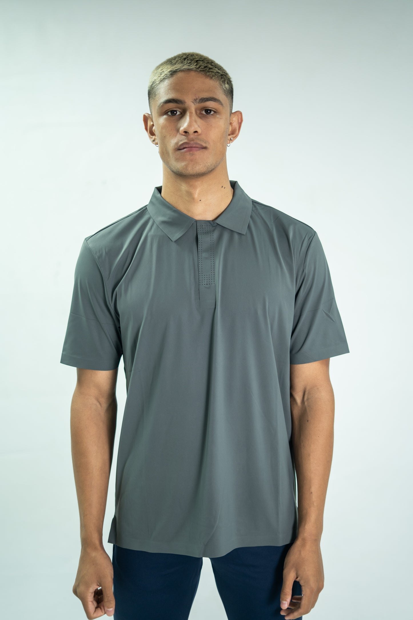 Man wearing a gray polo shirt against a white background

