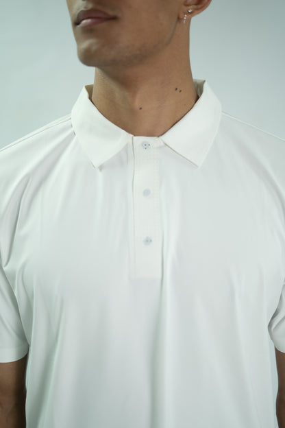 Close-up of a person wearing a white polo shirt against a light gray background


