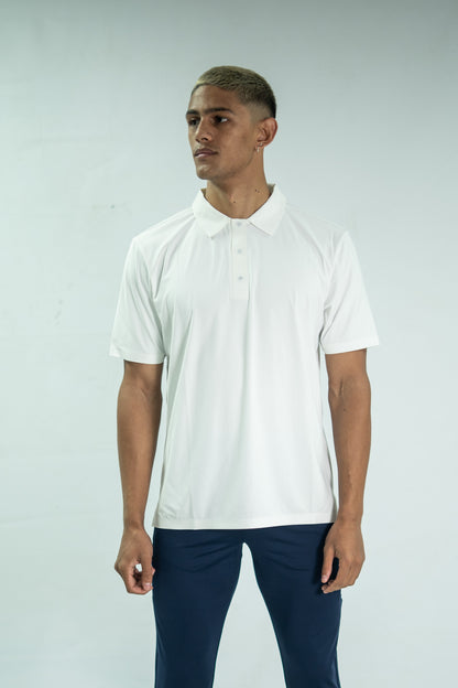 Man wearing a white polo shirt and dark pants against a light gray background

