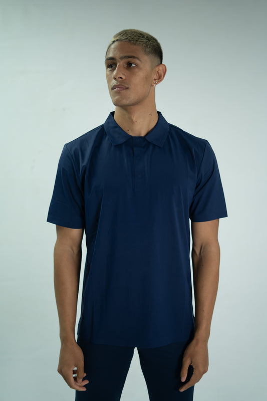Man wearing a navy blue polo shirt against a light gray background

