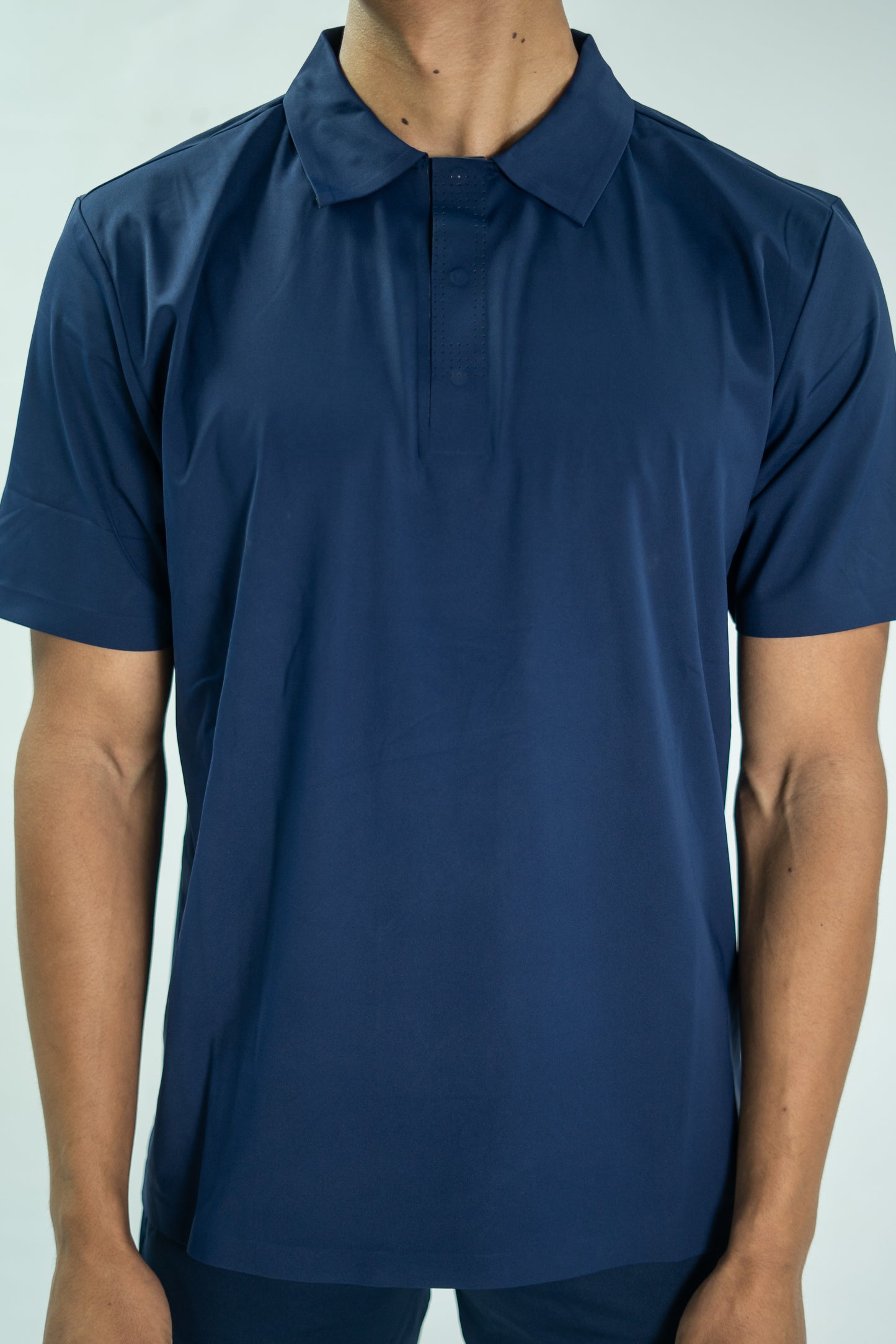 Navy blue short-sleeve shirt worn by a person on a light gray background

