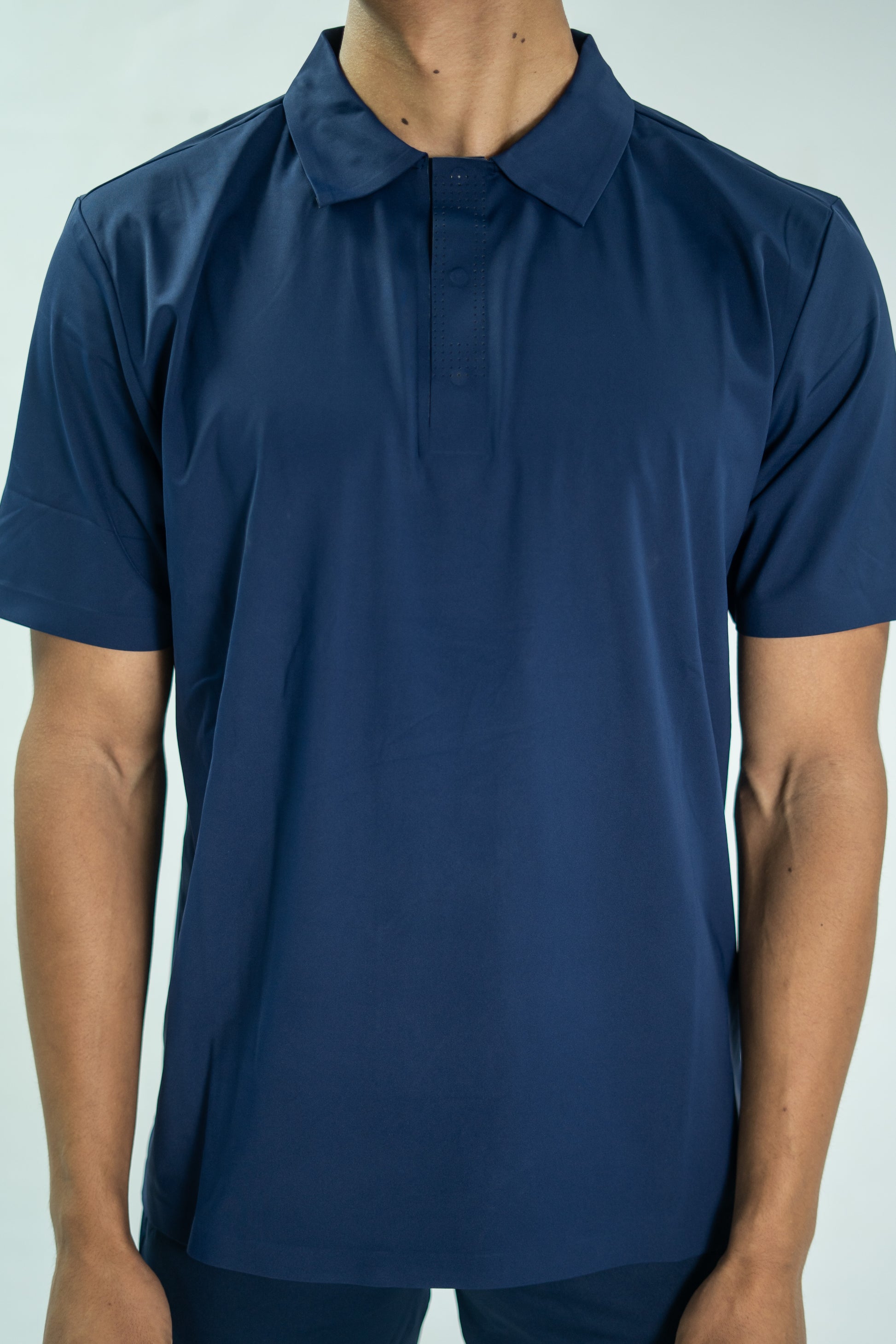 Navy blue short-sleeve shirt worn by a person on a light gray background

