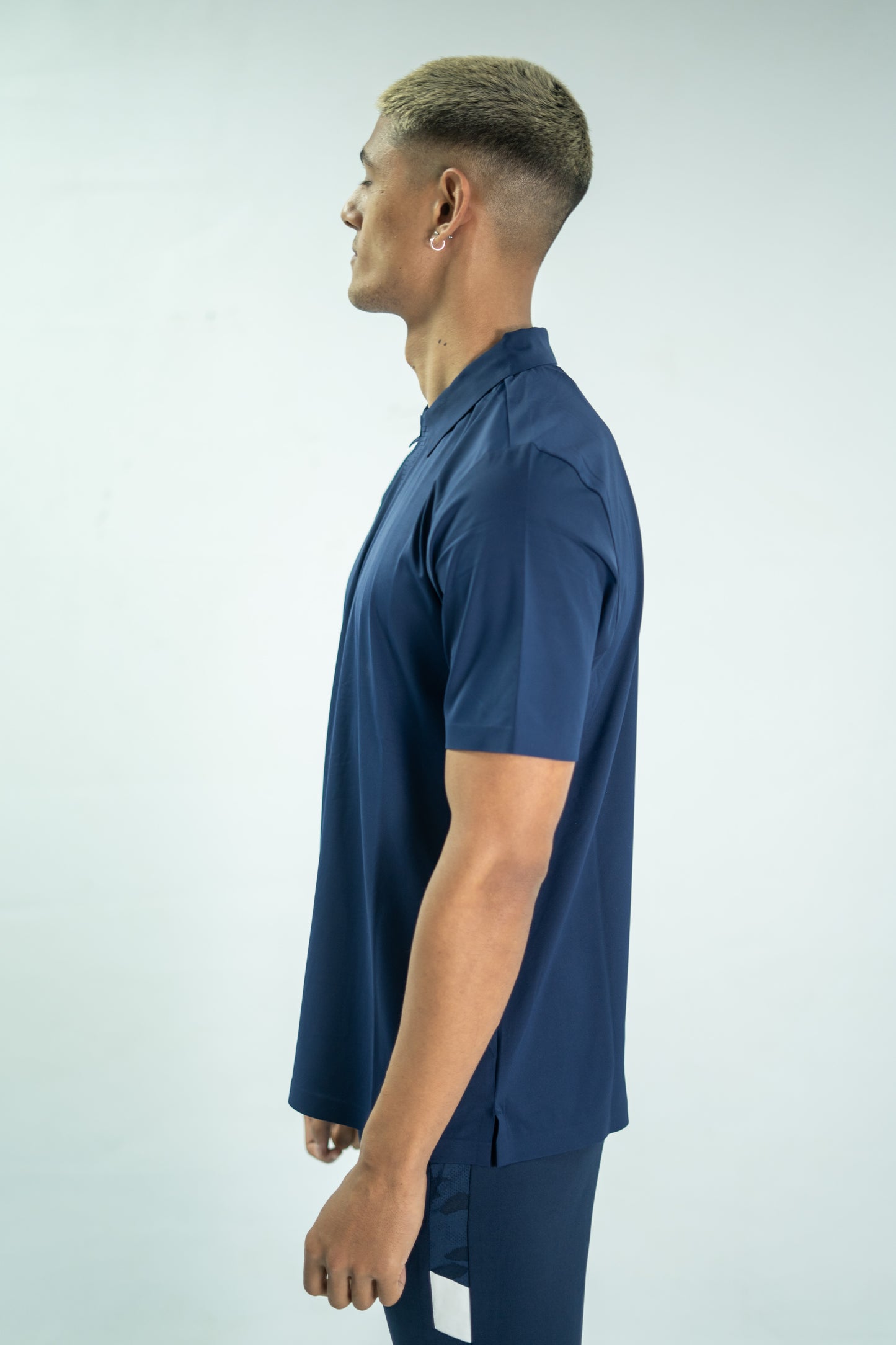 Person wearing a navy blue shirt and pants on a light gray background


