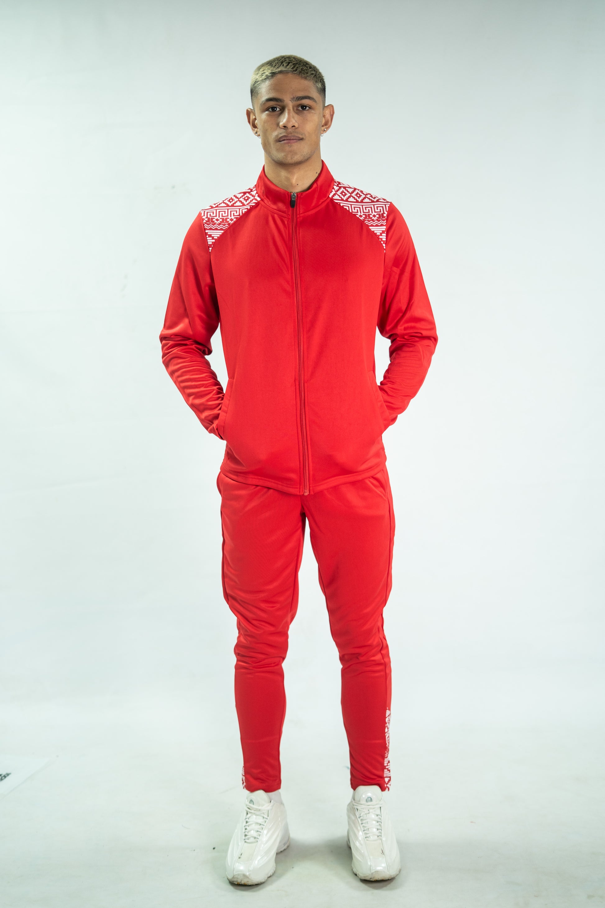 Person wearing a red tracksuit with white accents on a white background

