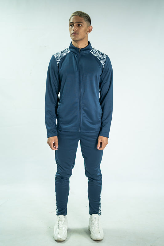 Man wearing a blue tracksuit with white accents on a light gray background

