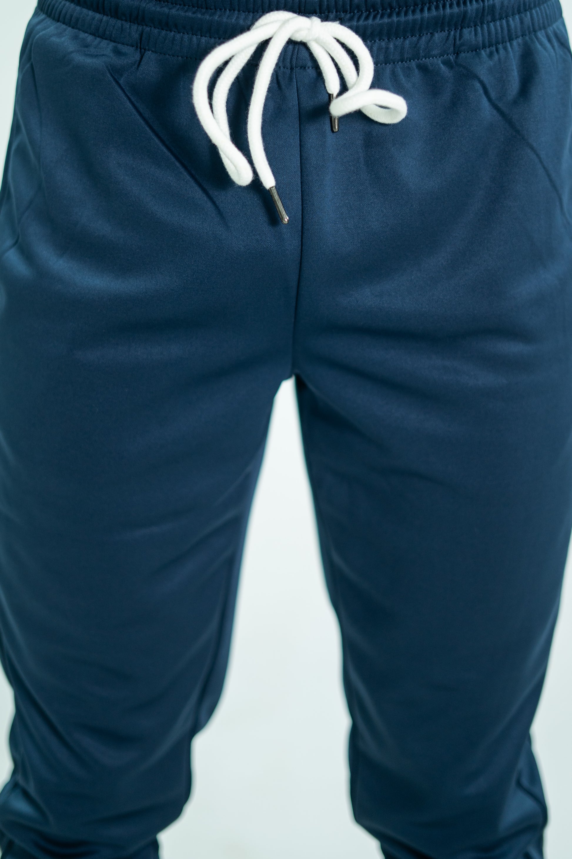 Navy blue pants with white drawstring on a light gray background

