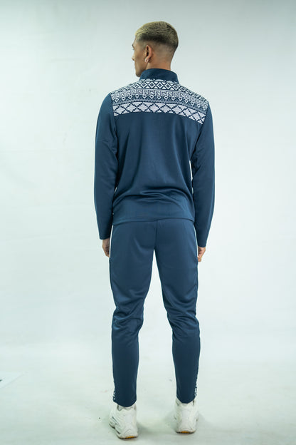 Person wearing a blue tracksuit with a patterned chest area on a white background

