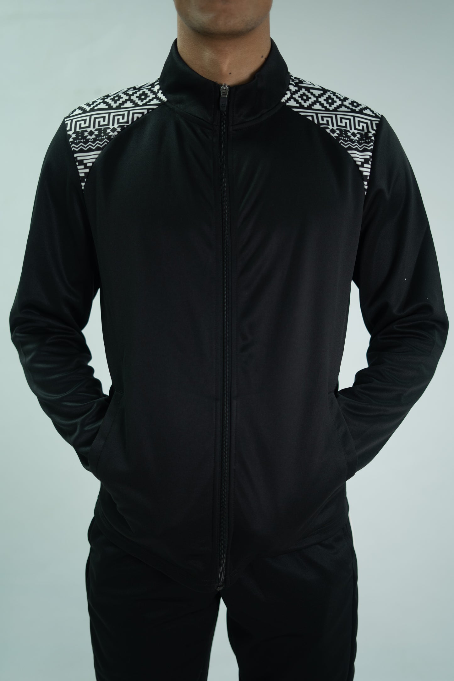 Black tracksuit with patterned shoulders on a gray background

