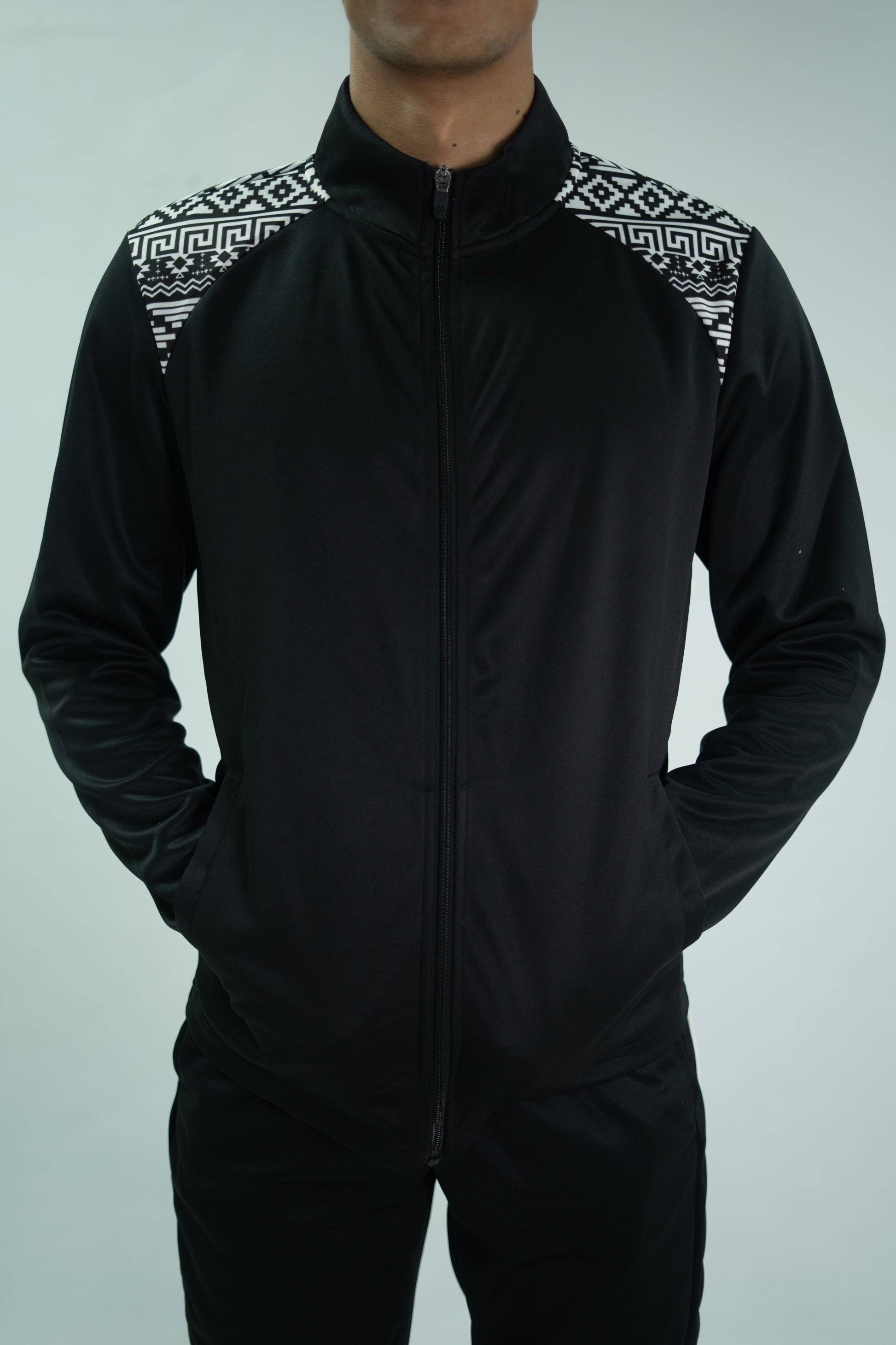 Black tracksuit with patterned shoulders on a gray background

