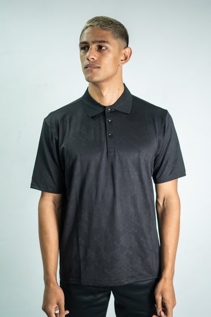 Man wearing a black polo shirt against a plain background

