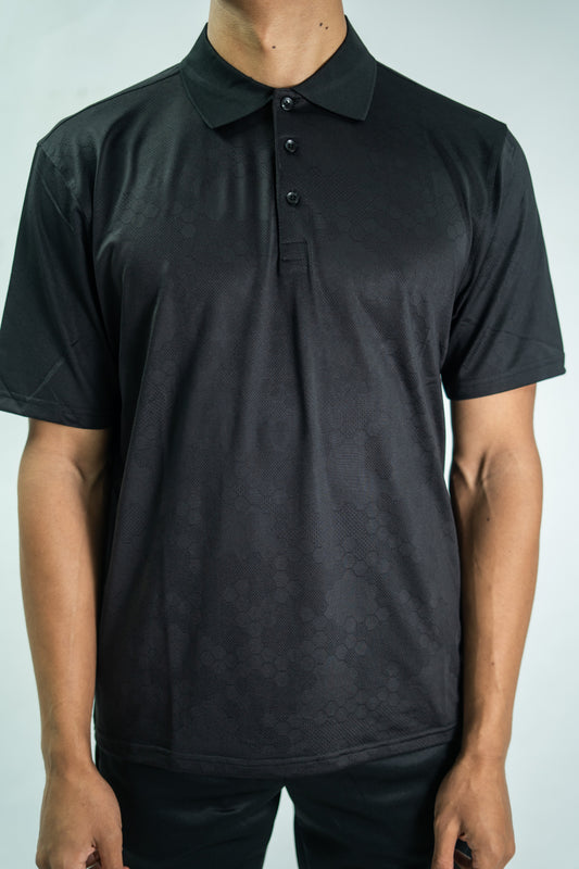 Person wearing a black polo shirt against a plain background

