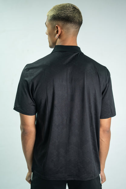 Man wearing a black polo shirt against a light gray background

