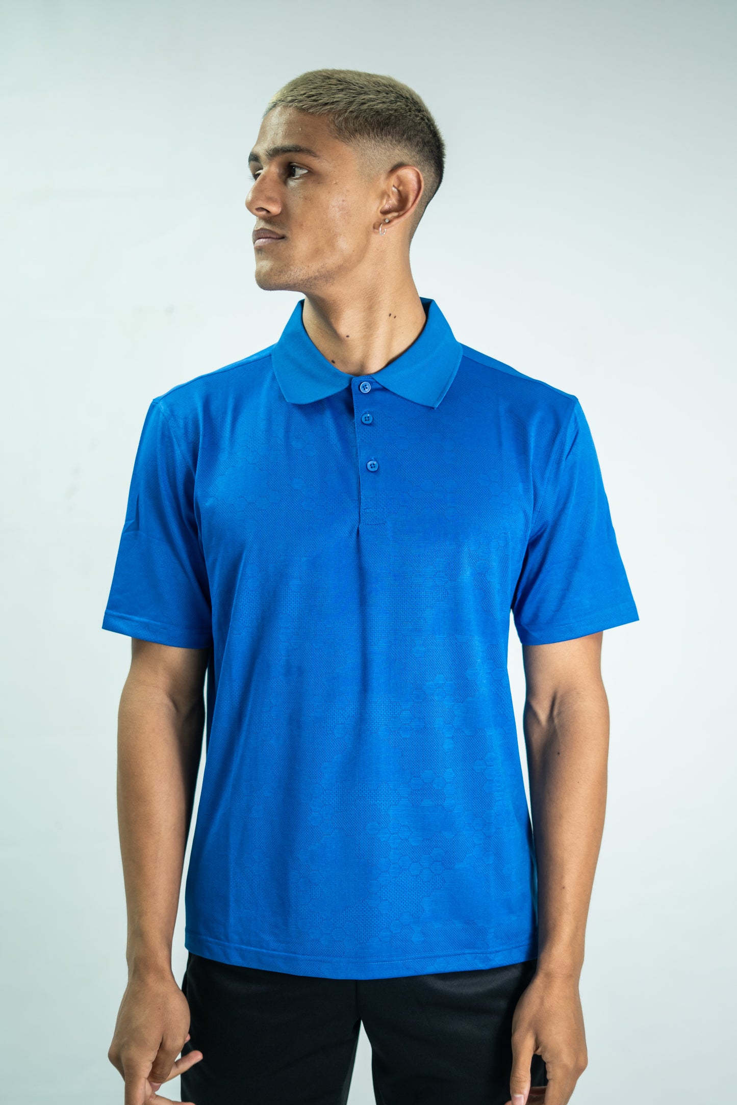 Person wearing a blue polo shirt against a white background

