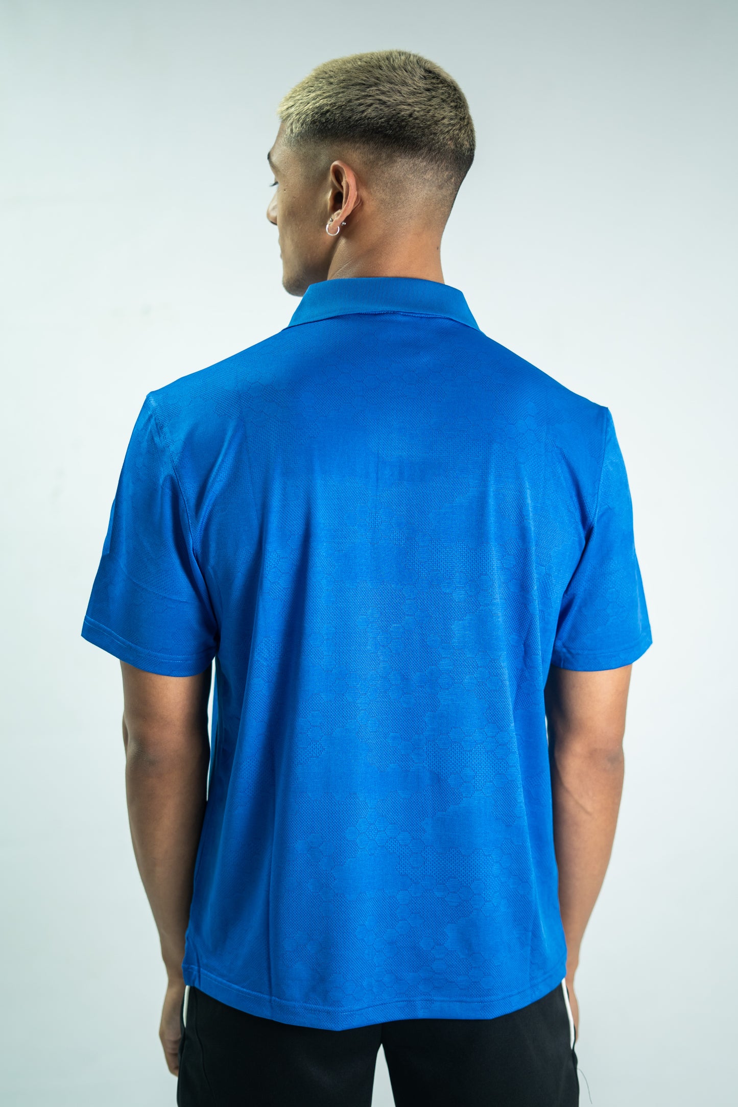 Person wearing a blue polo shirt against a white background

