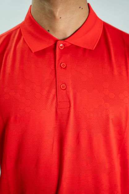 Close-up of a red textured polo shirt with buttons on a light gray background

