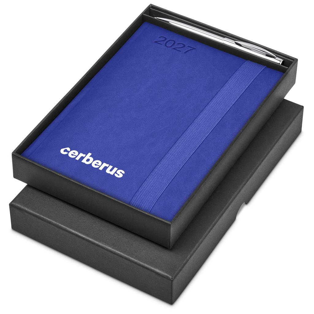 A black presentation box containing a blue 2027 journal with the brand name cerberus printed in white, along with a silver pen, set against a plain white background.


