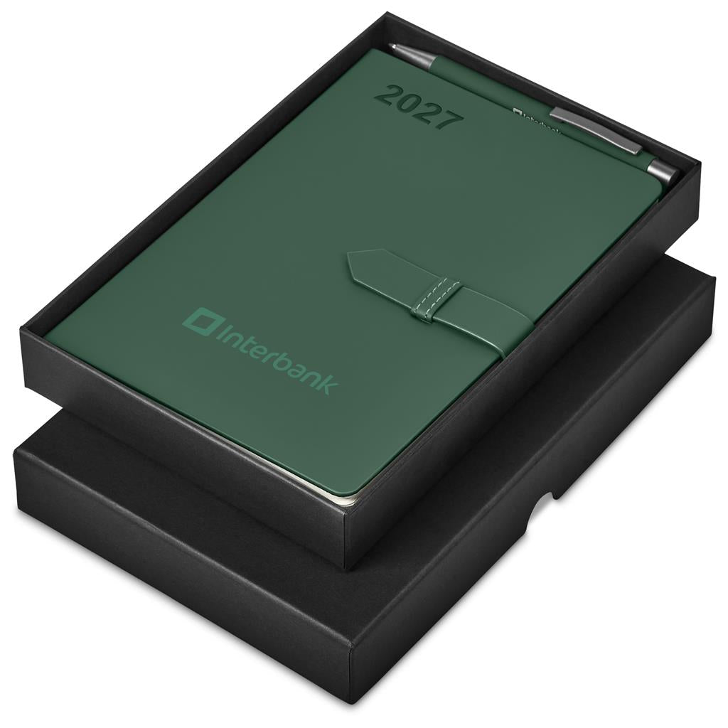 A dark green Interbank 2027 pocket calendar with a pen, presented in an open black gift box on a white background.

