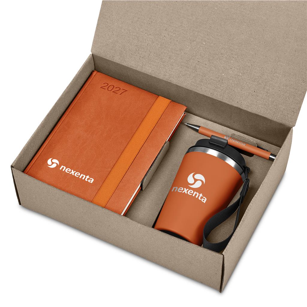 A gift set in a brown cardboard box containing an orange 2027 notebook, an orange insulated tumbler with a black lid and wrist strap, and a matching orange pen. The items are branded with the 'nexenta' logo.

