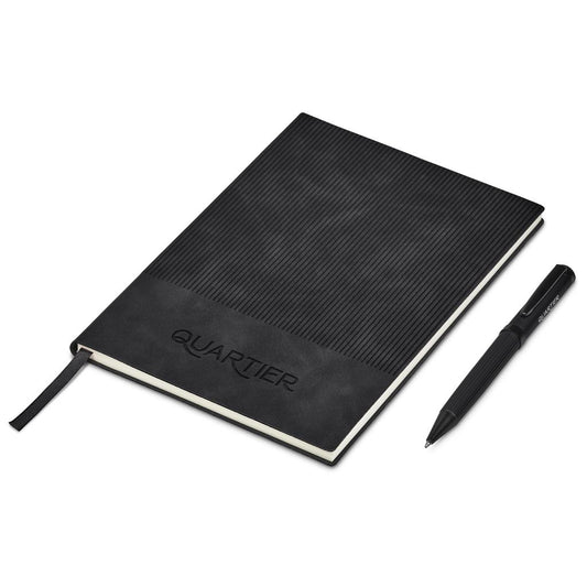 Black notebook with textured cover and pen on a white background, featuring the brand 'Quartier'.

