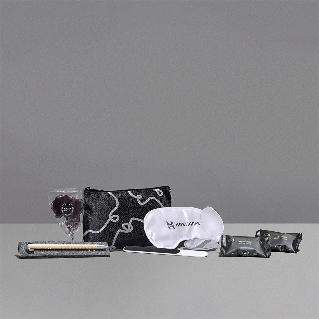 Collection of travel items including a pouch, mask, and other products on a gray background

